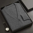 Gray cardigan in a black box with a watch on a dark surface