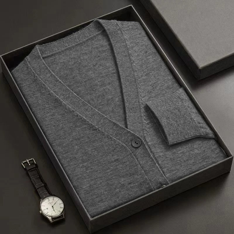 Gray cardigan in a black box with a watch on a dark surface