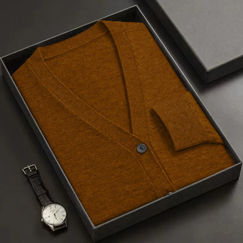 Brown cardigan in a box with a watch on a dark surface