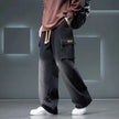 Person wearing black cargo pants with a gray background