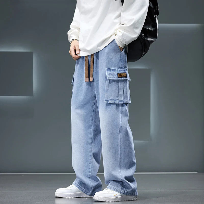 Person wearing light blue cargo pants with a white shirt and white sneakers on a gray background