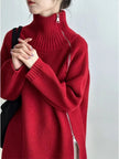 Person wearing a red sweater with a zipper on a plain background