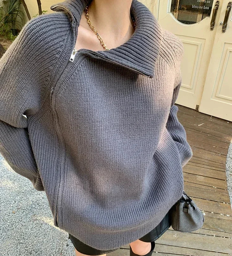Person wearing a gray sweater on a wooden deck