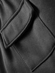 Close-up of a black coat with a collar and button detail.