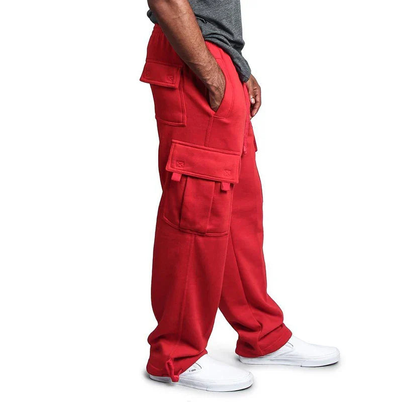 Red cargo pants worn by a person on a white background