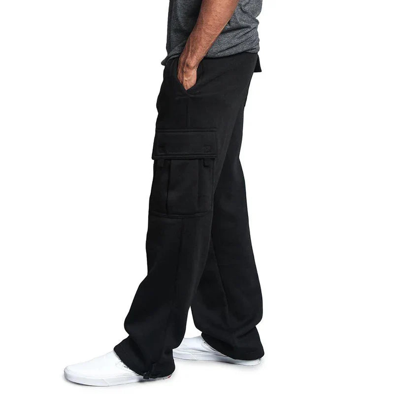 Person wearing black cargo pants on a white background