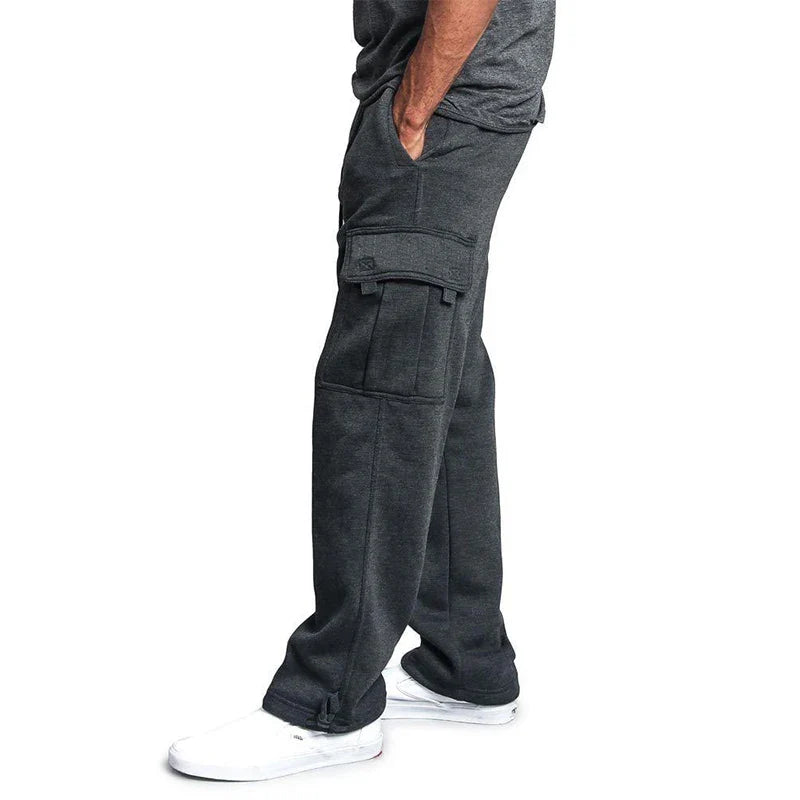 Person wearing dark gray cargo pants on a white background