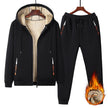 Black tracksuit with flame design on pants, on hangers against a white background