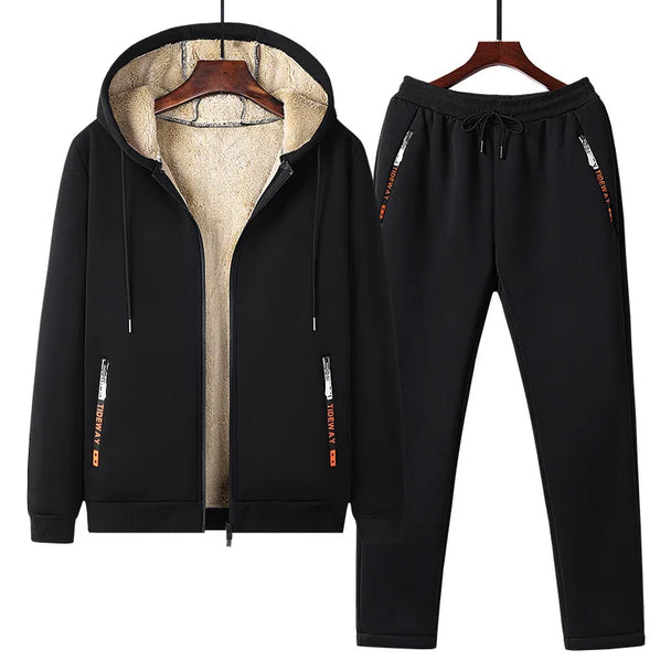 Black tracksuit with hood and pants on hangers against a white background