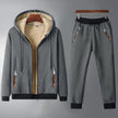 Gray fleece-lined hoodie and pants set on hangers against a gray background
