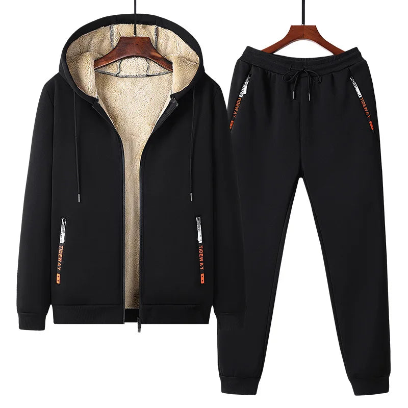 Black tracksuit with hood and jogger pants on hangers against a white background