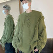 Person wearing a green fringed sweater with a mirror reflection.