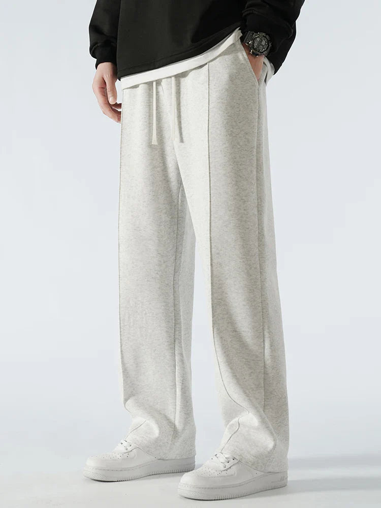 Person wearing light gray sweatpants on a white background