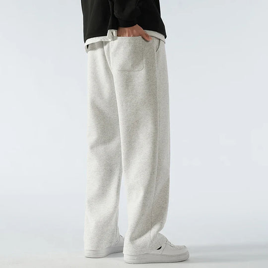 Person wearing light gray sweatpants on a white background